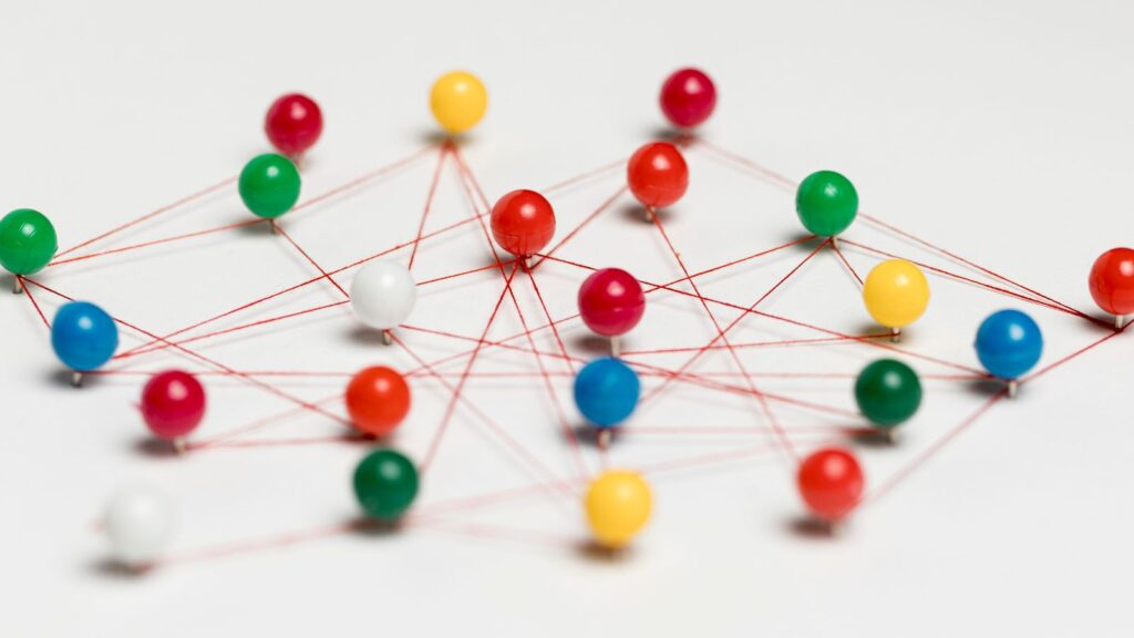 Conceptual network of colorful pins connected by red strings representing connections and pathways, symbolizing the complexity of planning an ERP Migration Roadmap from legacy systems to Microsoft Dynamics 365 Business Central.